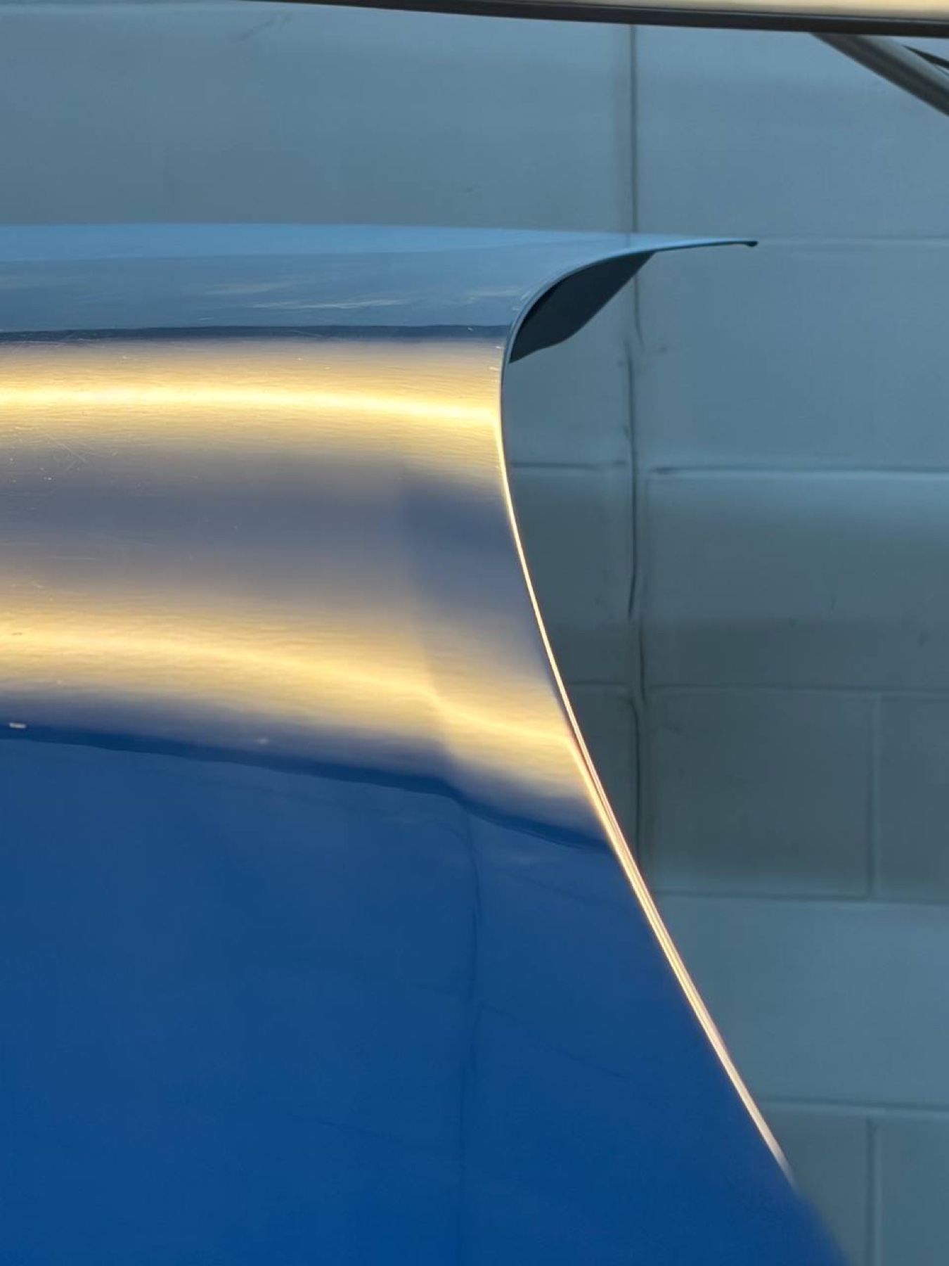 Blue vehicle quarter panel after paintless dent repair